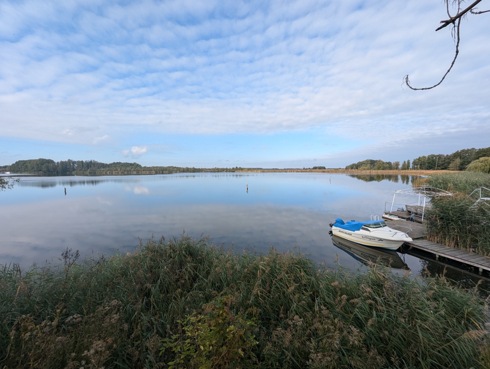 Brandenburger See mit dramatischen Wolken und Boot am Steg